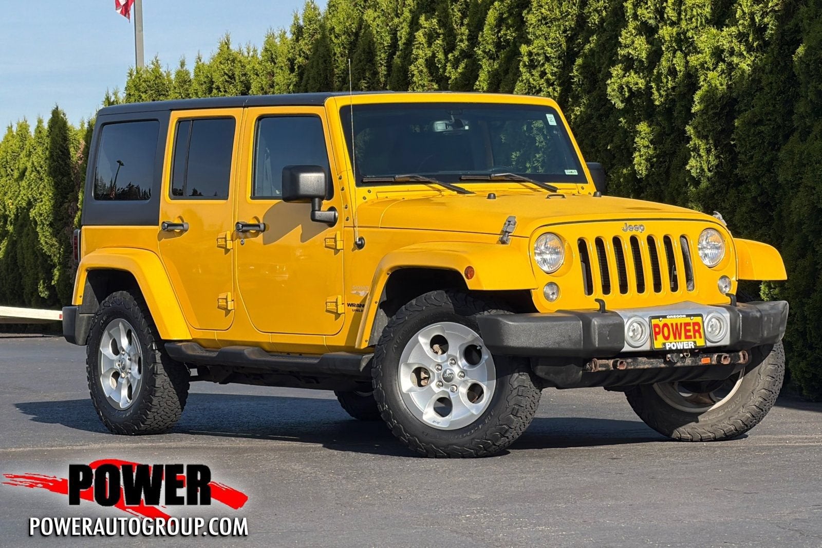2015 Jeep Wrangler Unlimited Sahara in Baja Yellow Cle — front three-quarter view